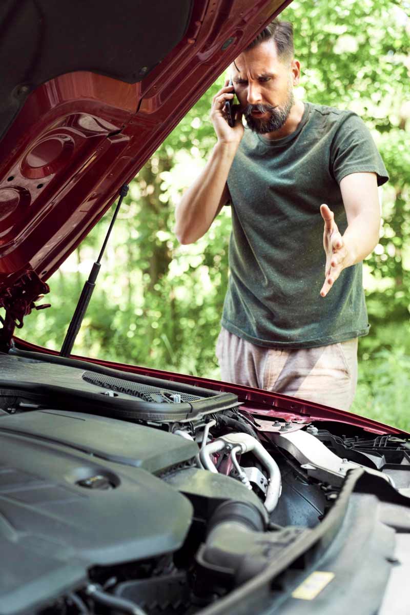 Junger Mann prüft Getriebeschaden bei Schrottauto Ankauf Dormagen